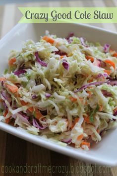 a white bowl filled with coleslaw slaw on top of a wooden table