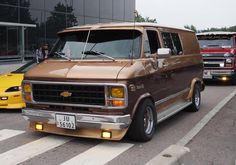 a brown van parked in front of a yellow car