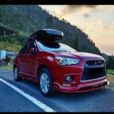 a red car is parked on the side of the road