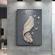 a large white feather is hanging on the wall