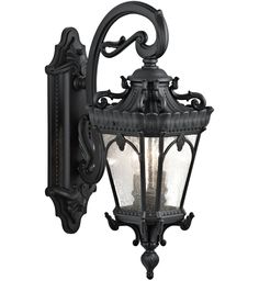 an old fashioned wall light with glass panels and ornate carvings on the front, in black