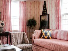 a living room filled with furniture and pink curtains