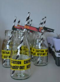 several empty glass bottles with black and yellow striped straws in them on a table