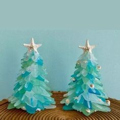 two plastic christmas trees sitting on top of a wooden table