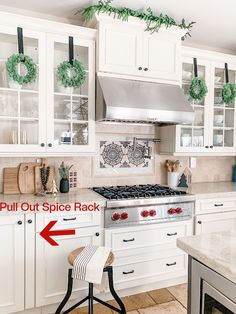 a kitchen with white cabinets and green wreaths