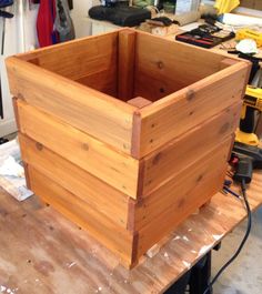 a wooden box sitting on top of a table next to a workbench and tools