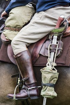 two people sitting on the back of a horse wearing boots and riding gaiters