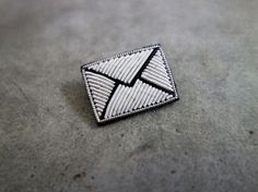 a silver pin sitting on top of a cement floor