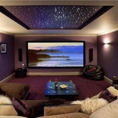 a living room with couches and a flat screen tv on the wall in front of it