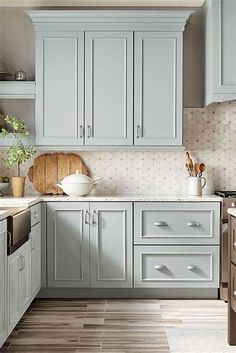 a kitchen filled with lots of gray cabinets and counter top space next to a sink