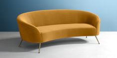 a yellow couch sitting on top of a white floor next to a blue and gray wall