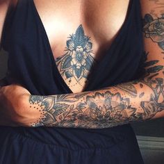 a woman with tattoos on her arms and chest