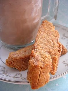 two pieces of food on a plate next to a glass of chocolate milkshake