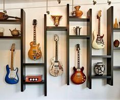 several guitars are displayed on shelves in a room