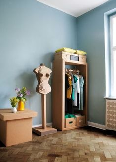 a room with blue walls and wooden flooring has a mannequin on the shelf