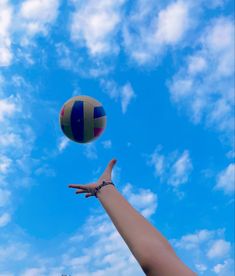 a person reaching for a beach ball in the air