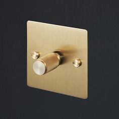 the light switch is gold and has two white lights on each side, with an illuminated bulb