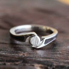 a close up of a silver ring on a wooden table with wood grained surface