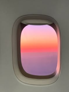 an airplane window with the sun setting in the sky as seen through it's windows