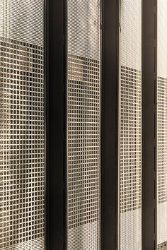 three black and white metal partitions with perfored screens on the wall next to each other