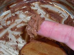 a hand is stirring chocolate into a bowl