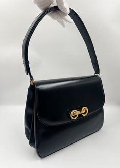 A stunning vintage Gucci box bag crafted from black leather with a clever strap so that can be as a shoulder bag or a cross body. A unique GG pinch clasp opens and closes the bag. Inside there are multiple compartments, slip pockets and a zipped pocket for your valuables. This bag is in good vintage condition with some minor scratches to the leather. There is a slight tear to the back panel near to bend of flap. Send me a message if you wish to see further photos or videos. Comes with the original Gucci dust bag. Width: 25cm Depth:7cm Height: 22cm Strap drop: 20-40cm Vintage Rectangular Shoulder Bag With Horsebit Detail, Formal Satchel Shoulder Bag With Horsebit Detail, Vintage Rectangular Shoulder Bag With Turn-lock Closure, Retro Business Shoulder Bag With Gold-tone Hardware, Vintage Formal Bags With Turn-lock Closure, Vintage Shoulder Bag With Horsebit Detail, Vintage Shoulder Bag With Horsebit Detail For Everyday, Formal Crossbody Shoulder Bag With Horsebit Detail, Classic Rectangular Bags With Horsebit Detail