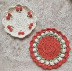 two crocheted coasters sitting on top of a table