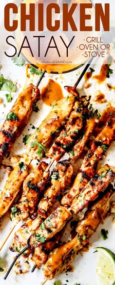 chicken satay is served on skewers with sauce and garnishes