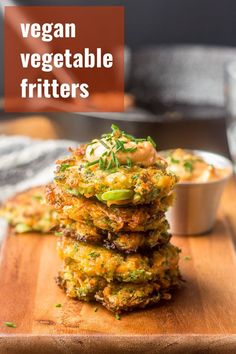 a stack of vegetable fritters sitting on top of a wooden cutting board