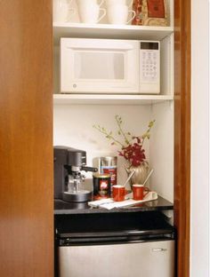 a small kitchen with white cabinets and black counter tops