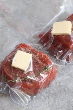 two pieces of meat wrapped in plastic with cheese on top