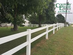 a white fence is in front of some trees