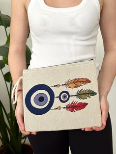 Evil Eye Pouch in Cotton Canvas - Handmade Fabric bag - Gift for her Small Pouch made with 100% natural (ecru) cotton canvas. No lining. Ecru metal zip. Decorated with an embroidered evil eye design on the front. This little pouch is perfect for carrying small accessories. Cream Zipper Pouch As Gift, Eco-friendly Beige Canvas Pouch Bag, Beige Pouch Canvas Bag As Gift, Gift Beige Pouch Canvas Bag, Beige Pouch Clutch As Gift, Beige Pouch Clutch For Gift, Handmade Cream Clutch For Daily Use, Eco-friendly Cream Canvas Bag For Gifts, Eco-friendly Cream Canvas Bag As Gift