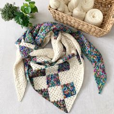 a crocheted scarf next to a basket of yarn