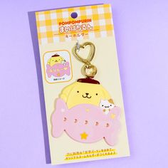 an animal shaped keychain is shown on a purple background with a white and yellow checkered tag