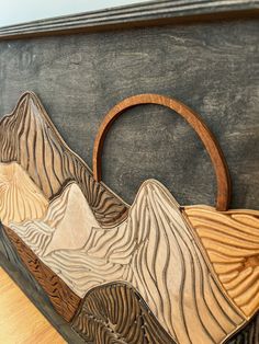 a wooden bag sitting on top of a table next to a blackboard with mountains in it