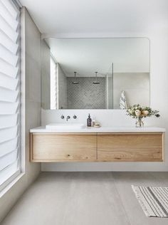 a bathroom with a sink, mirror and rug