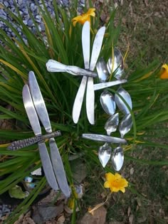 spoons and forks stuck in the grass with daffodils