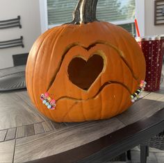 a pumpkin with a heart cut out of it's side sitting on a table