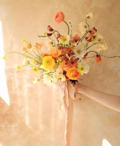 a woman holding a bouquet of flowers in her hand