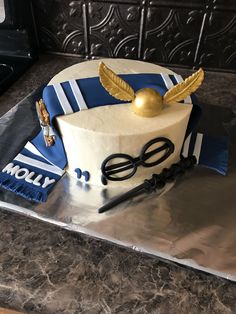 a harry potter themed birthday cake with glasses and golden snitches on top