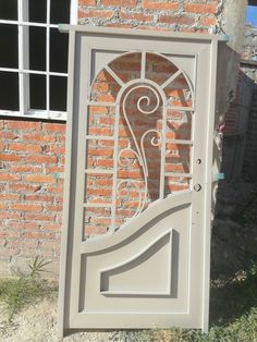 an open door with a decorative design on the side of a brick wall in front of a window