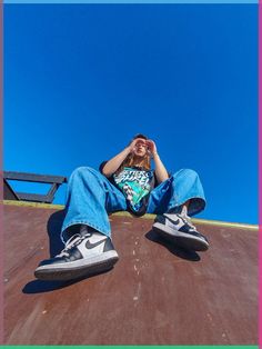 a person sitting on top of a skateboard ramp with their hands to their face