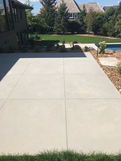 an empty concrete patio in front of a house