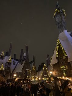 people are standing in front of buildings with christmas lights on them