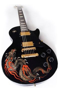 a black guitar with red and yellow dragon decals on it's body, sitting against a white background