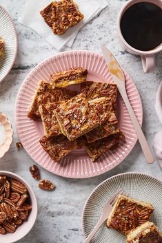 pecan bars on pink plates next to coffee