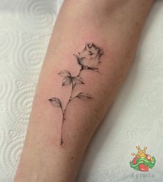 a small rose tattoo on the left arm and lower arm, with leaves growing out of it