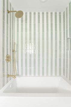 a white bath tub sitting next to a shower head