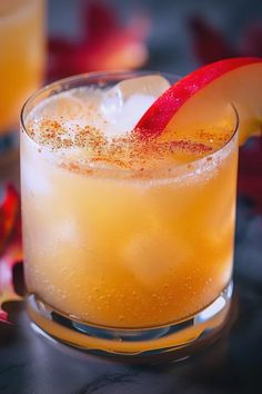 a close up of a drink in a glass with an apple slice on the rim